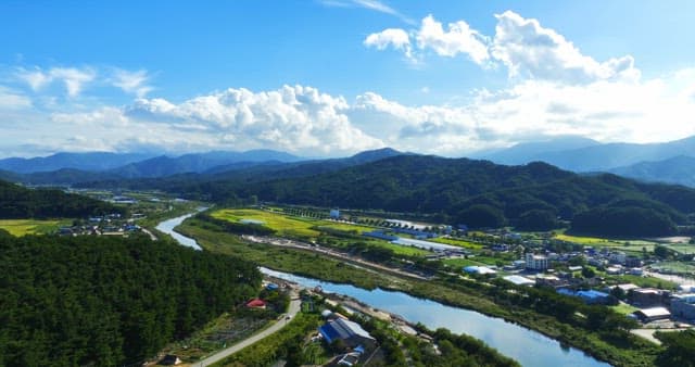 Scenic river flowing through lush green fields and mountains