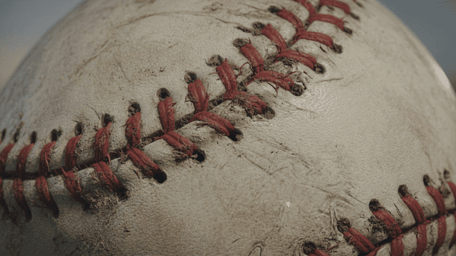 Close-up of a worn baseball with red stitching