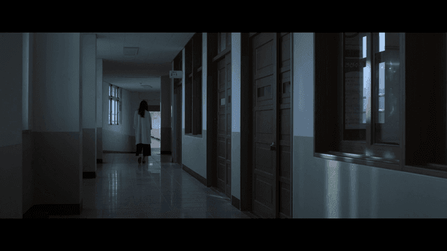 어두운 복도를 걷는 여성