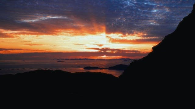 산과 바다 위의 생동감 넘치는 일몰