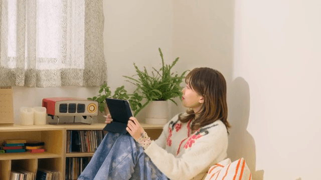 Woman using tablet in cozy room and looking out window