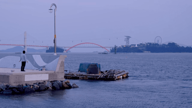 해질녘 바닷가에서 낚시하는 사람