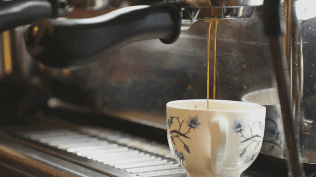 꽃무늬 컵에 에스프레소가 내려오는 장면