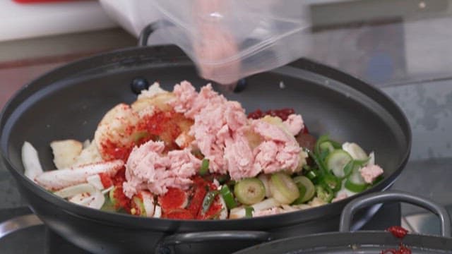 다진 햄을 채소와 고춧가루가 버무려진 팬에 넣기