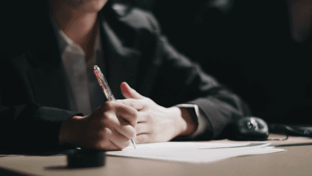 Prisoner giving statement in interrogation room and investigator questioning him.