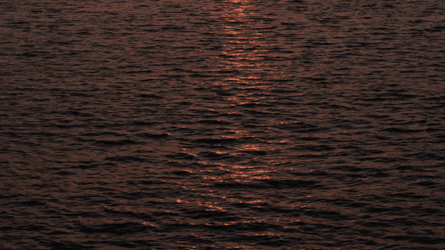 Sunset reflection on calm ocean waves