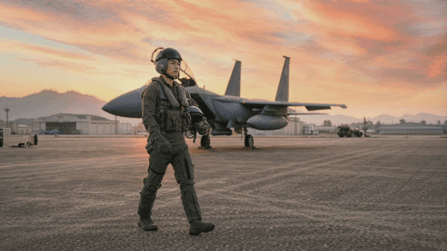 Fighter pilot walking on runway at sunset