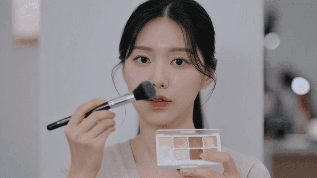 Woman applying makeup with brush