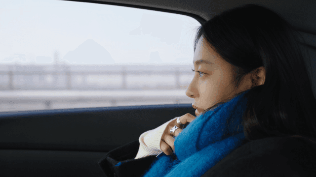 Profile of a woman looking out the taxi window at the road
