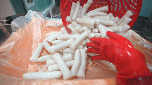 Rice cakes being poured into plastic wrap in kitchen