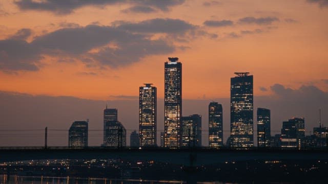 City skyline at sunset with bridge with subway passing by