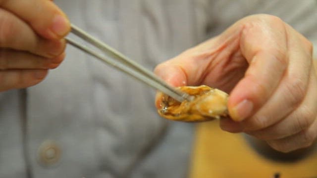 Soy sauce marinated crab being placed on rice