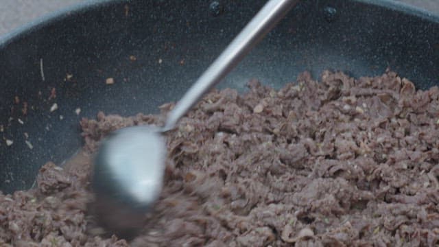 프라이팬에서 주걱으로 소불고기를 요리하는 모습