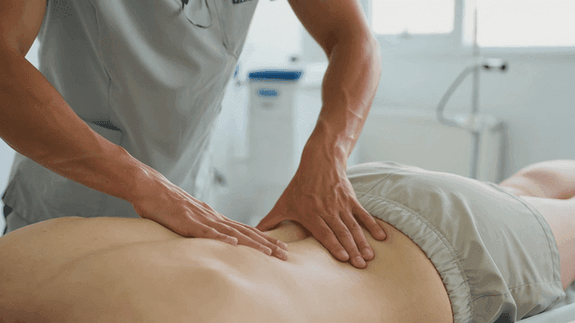 Massage therapist giving back massage