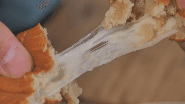 Cheese-filled bread being pulled apart