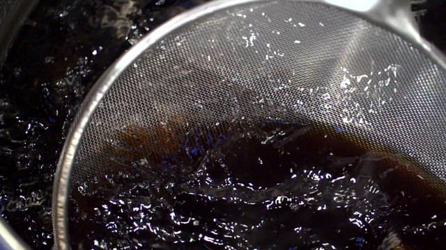 까만 소스에서 월계수 잎을 거르는 장면