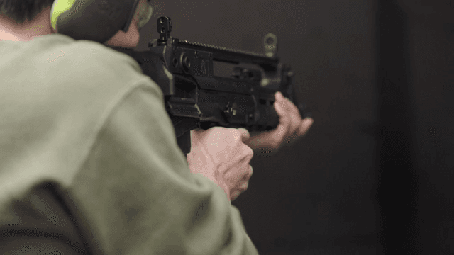 사격장에서 소총을 겨누는 사람