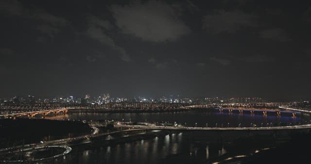 Night View of a Lit Cityscape and Bridge