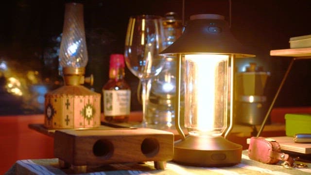 Glowing lantern on a cozy evening table with various items