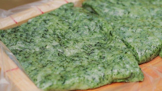 Green beewax rice cakes in a wooden tray