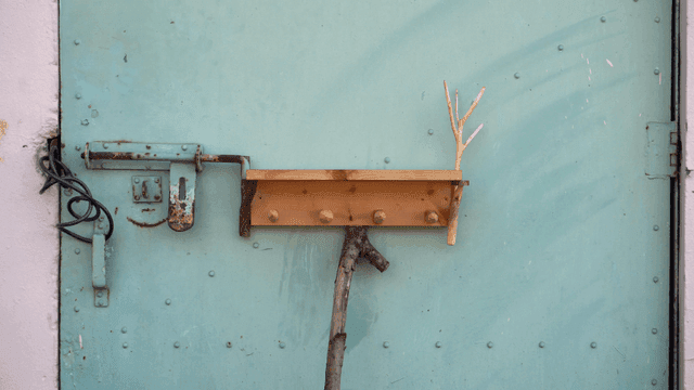 금속 문에 붙은 나뭇가지가 있는 목재 선반