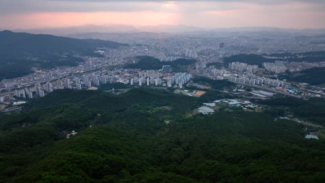 Sprawling cityscape with green mountains