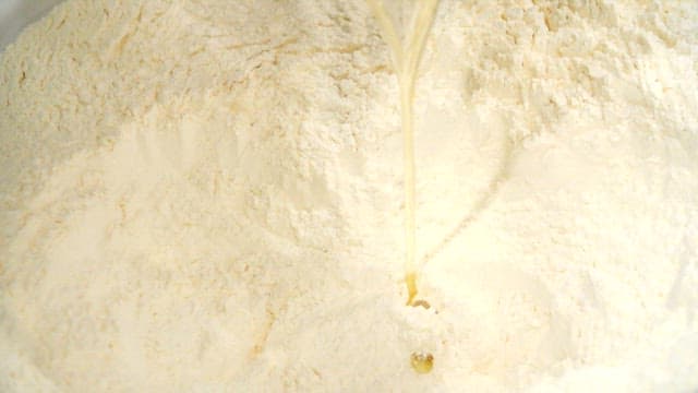 밀가루에 계란을 붓는 장면