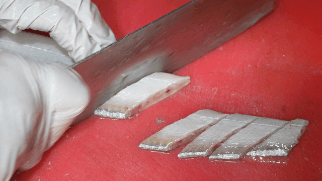 Slicing fresh fish fillet on a cutting board