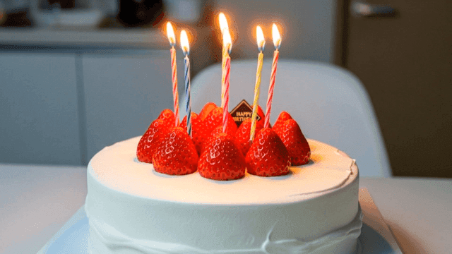 Birthday cake with lit candles.