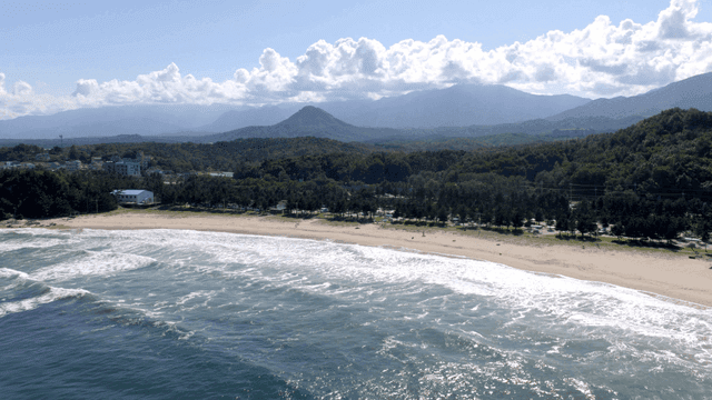 Serene beach with waves and mountains