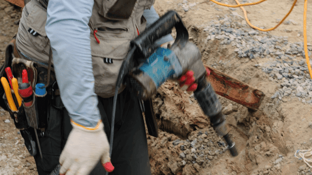 건설 현장에서 드릴을 사용하는 작업자