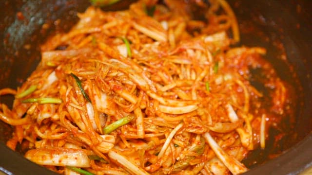 Cabbage kimchi mixed with spicy seasoning in a bowl