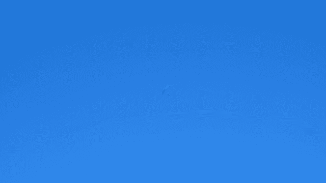 Paraglider soaring in the clear blue sky