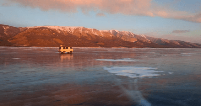 해질녘 얼어붙은 호수 위를 달리는 밴