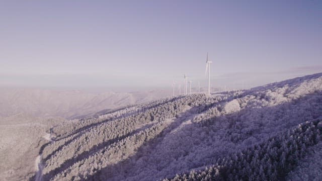 Wind Generators on Misty and Snowy Mountain in the Morning