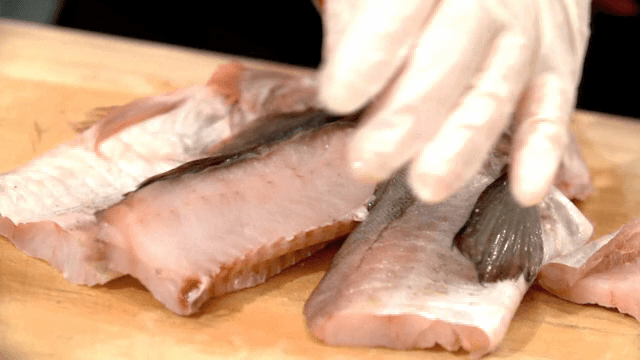 나무 도마 위에서 잘리는 명태