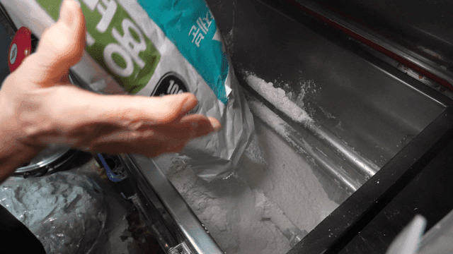 Flour being poured into a mixing machine