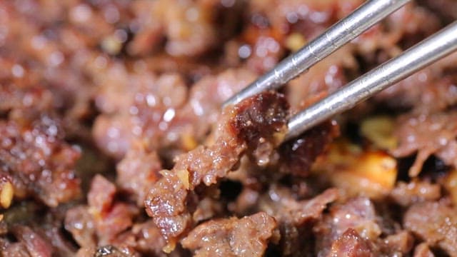 젓가락으로 집어드는 구운 소고기 떡갈비