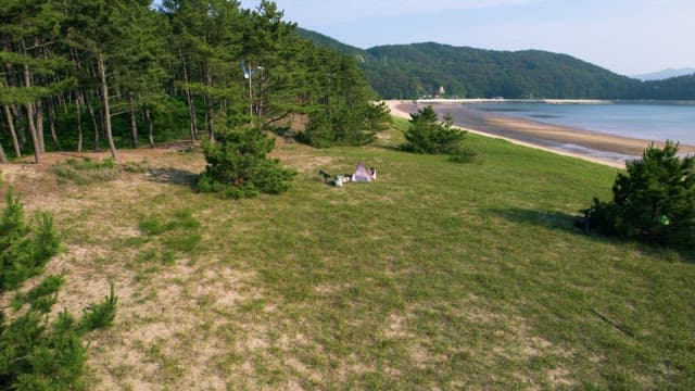 Person Preparing Camping by a Scenic Beach