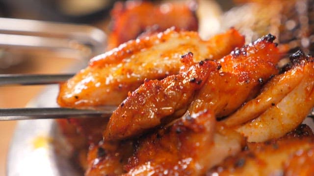 젓가락으로 잡은 숯불닭갈비