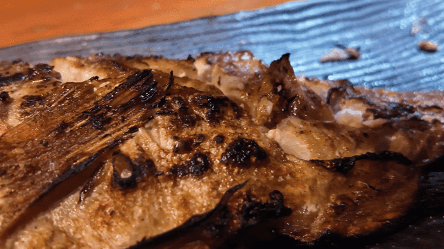Lemon juice sprinkled on grilled fish on plate