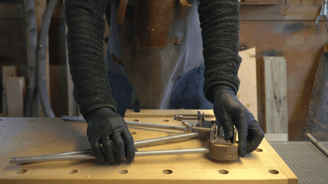 작업대에서 금속 막대를 조립하는 공예가