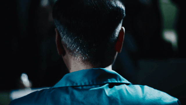 Back of prisoner being interrogated in dark room