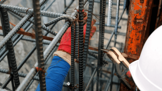 Worker welding steel bars at a construction site