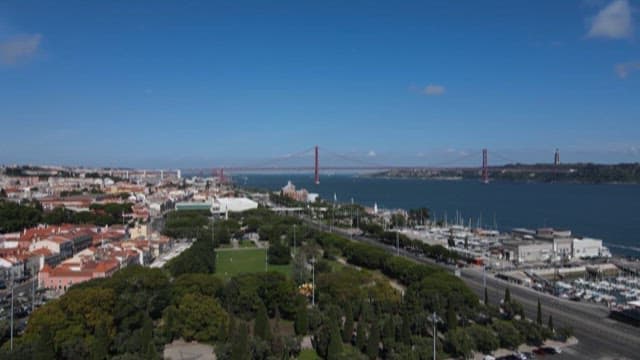 Riverside Cityscape with a Red Bridge on a Clear Day