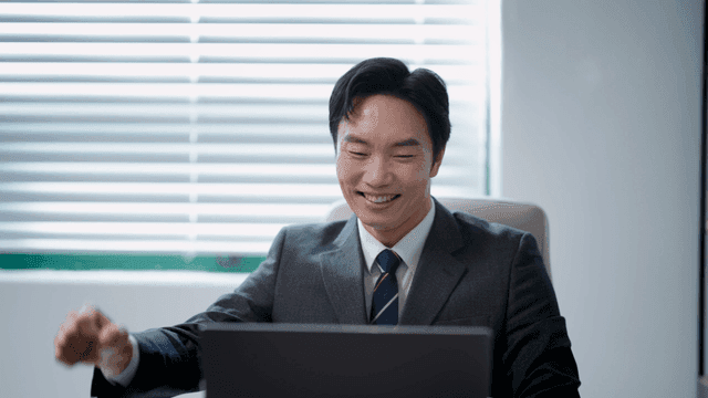 책상에 앉아 환호하는 사업가