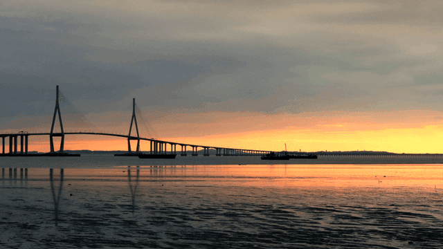 Bridge over calm water at sunset.