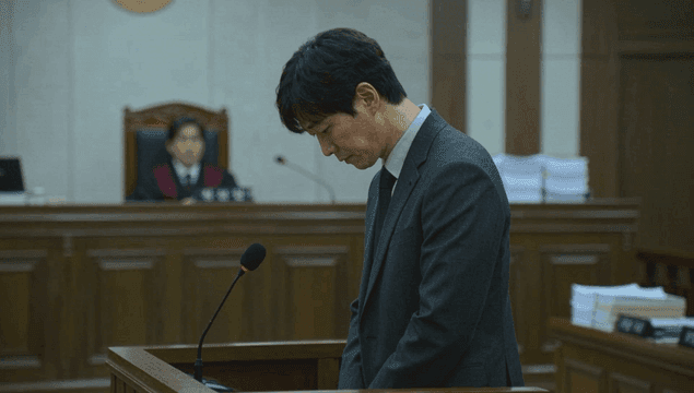 법정에서 반성하는 정장 입은 남성