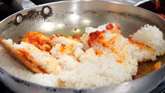 팬에서 김치 볶음밥을 저으며 요리하는 장면
