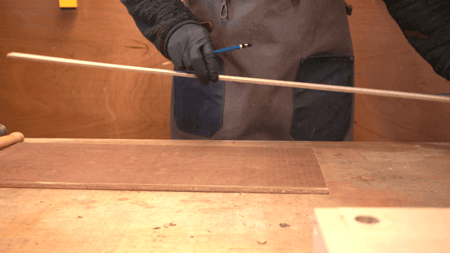 작업장에서 나무를 측정하는 사람